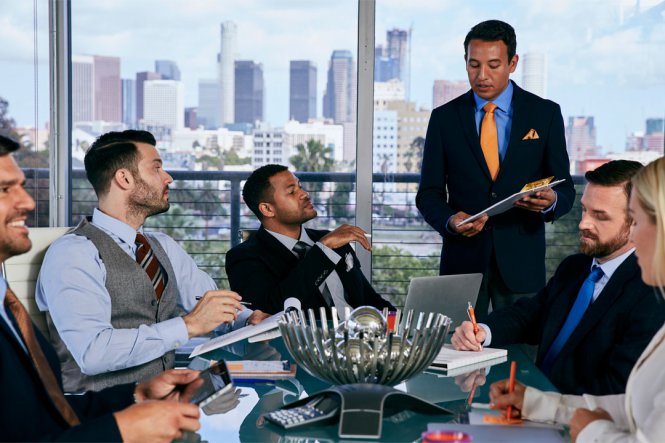 Men and women gather for a business meeting in an office.