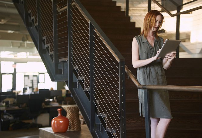 A woman using a tablet in an office setting.