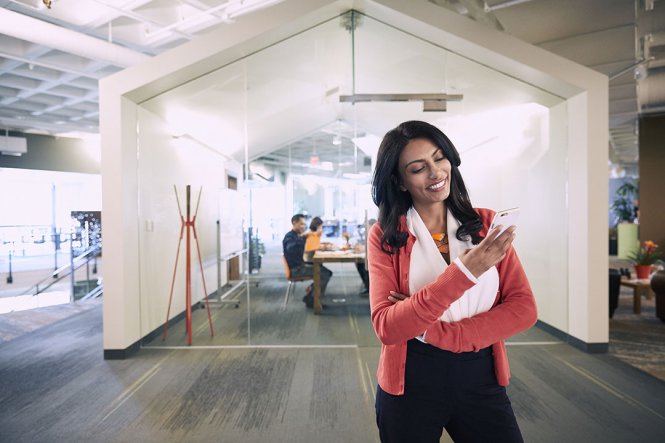 A professional using her smartphone to follow business trends.
