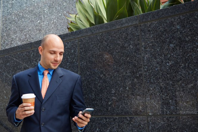Professional man looks at smartphone.