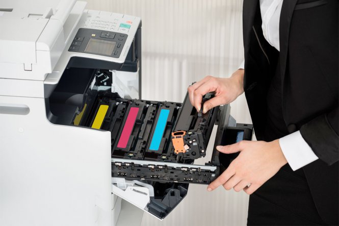 A woman replaces ink in fax machine