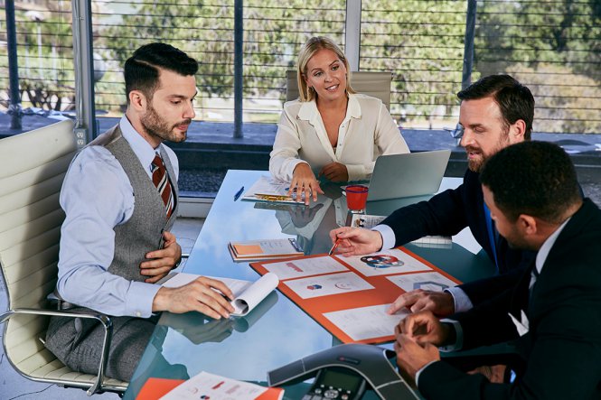 Three men and a woman having a meeting.