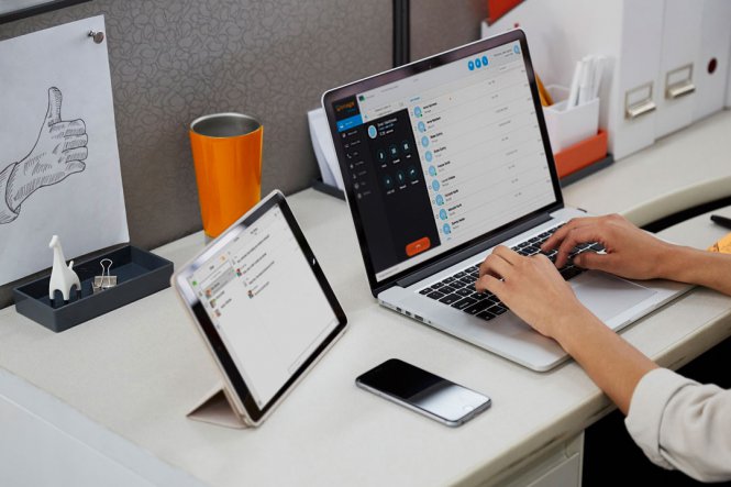 Woman types on a laptop at a desk.