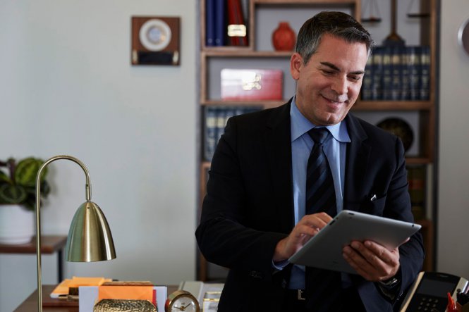 A man uses a tablet in an office.