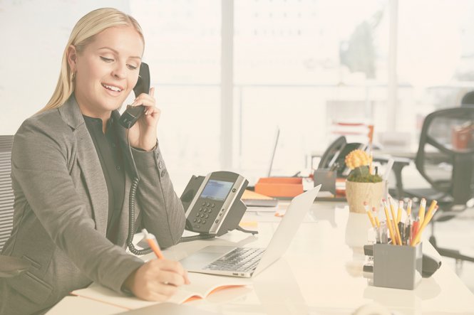 A woman sitting at her desk, speaking on the telephone.