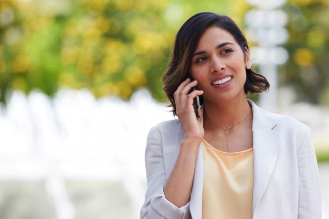 A woman speaking on her mobile phone outside.