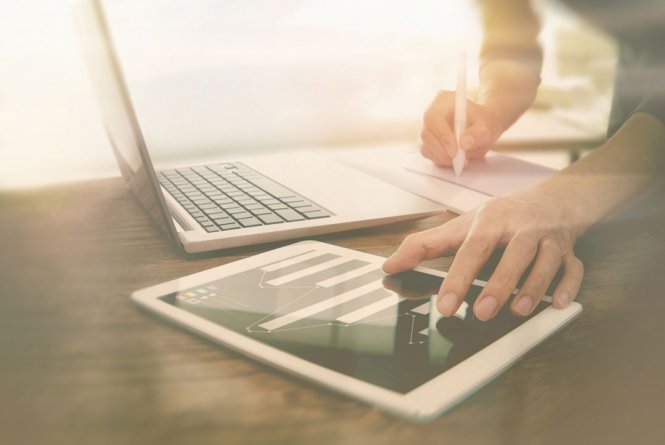 A man using a laptop and a tablet.