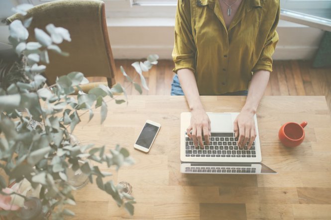 A woman sitting at home, using her laptop.
