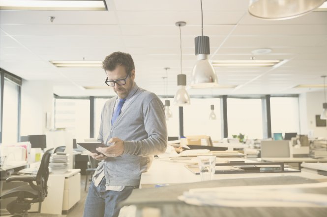 A man uses a tablet in an office.