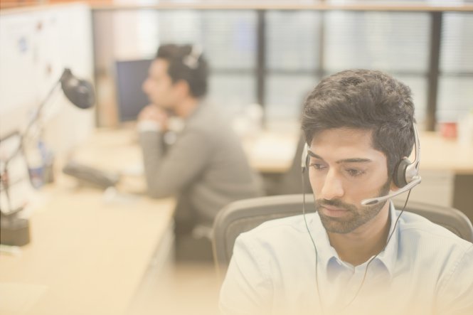 Call center operators, using their computers while talking on headsets.