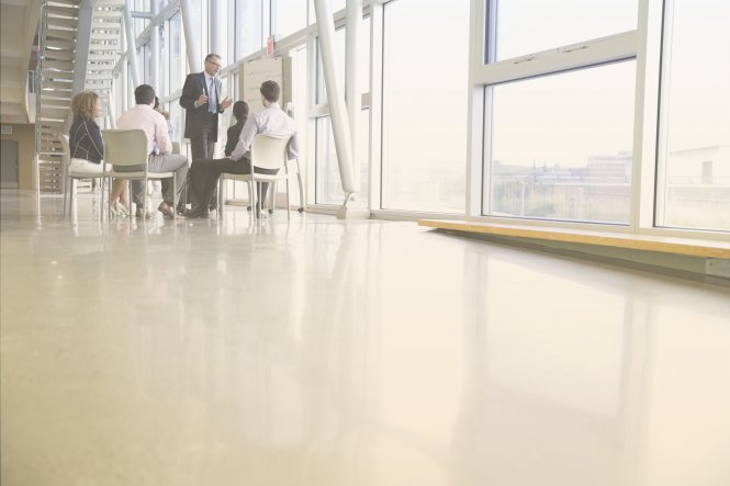 Colleagues in an office sitting in a circle, talking.