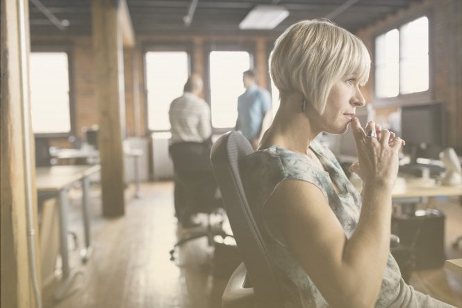 A woman sitting in her office, thinking.