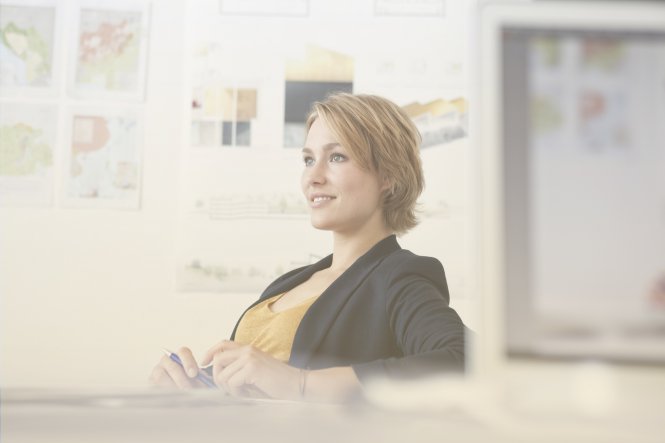 A smiling woman sitting at her desk.