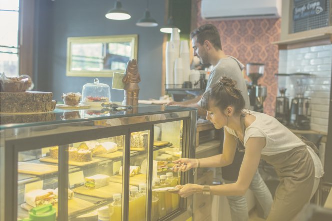 A man and woman working at a food retailer.