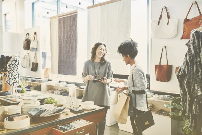 A retailer chatting with a customer, aided by CRM small-business tools.