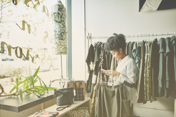 A woman in a retail store, using her mobile phone enhanced by customer service technology.