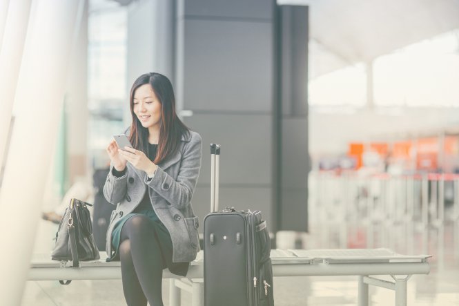 A woman on her mobile phone, enjoying herself thanks to customer experience management.