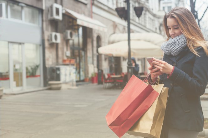 A woman using digital business technologies to shop online and in-store at the same time.