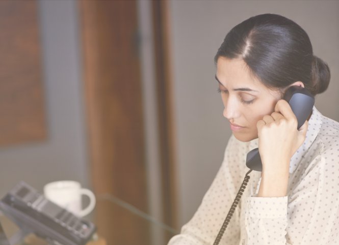 A woman using a cloud business process to help a customer over the phone.