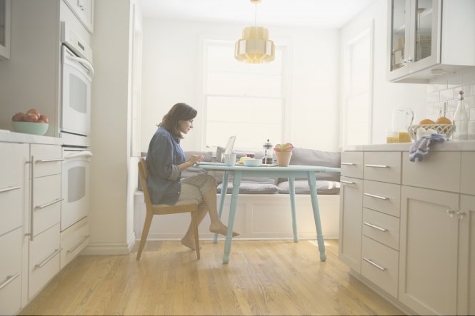 A woman using her kitchen as an office, because working from home benefits the environment.