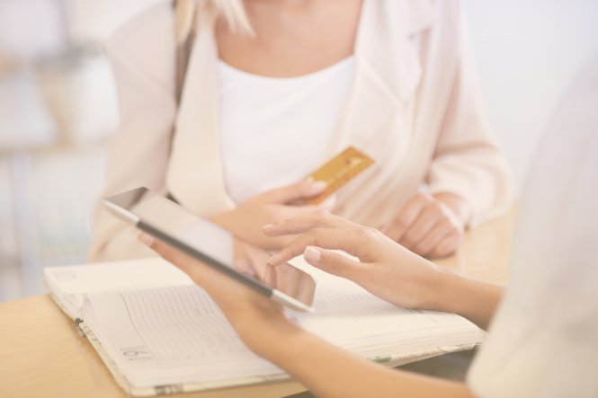 A woman using her credit card to make a purchase at a store, thanks to the contextual communications that kept her engaged with the brand.