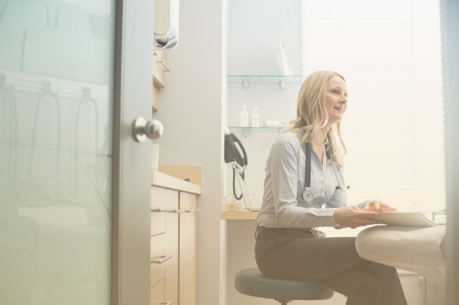 A doctor in a medical office using QoS bandwidth prioritization to route network traffic.