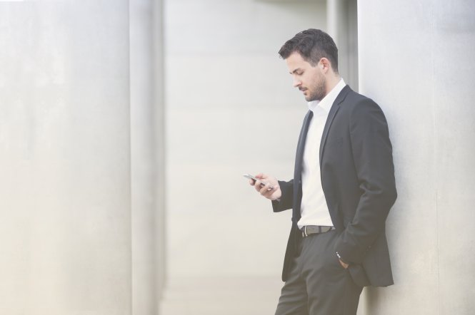 A businessman using his smartphone as his office phone.