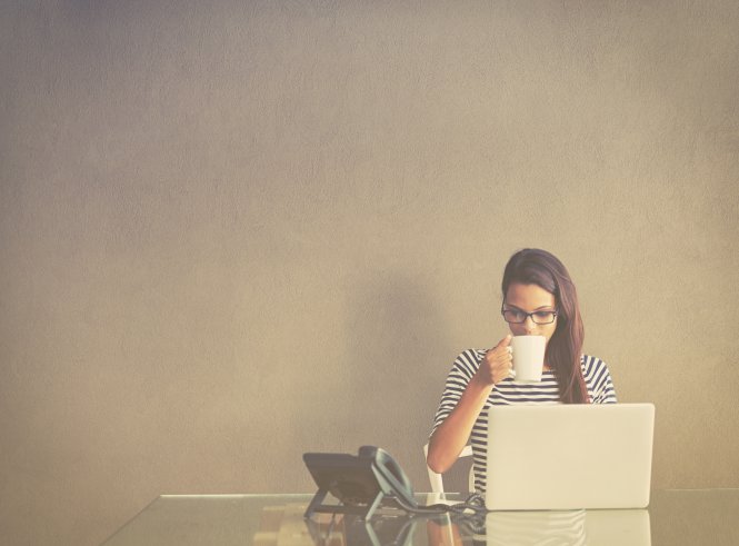 A woman ignoring a call because her cloud communications app identifies it as phone spam.