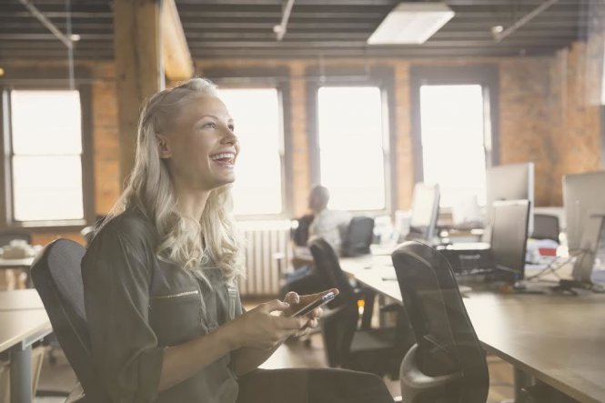 A woman using her company's old phone number on a new cloud phone system, thanks to number porting.