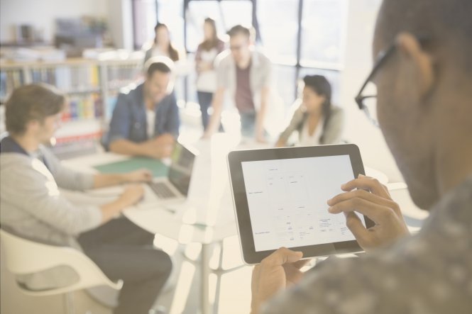 Workers in an office using a unified communications platform to communicate.