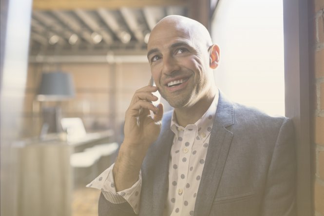 A man talking on his smartphone, enjoying QoS thanks to an MPLS connection.
