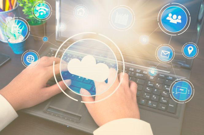 Person typing at laptop with cloud symbols representing UCaaS market