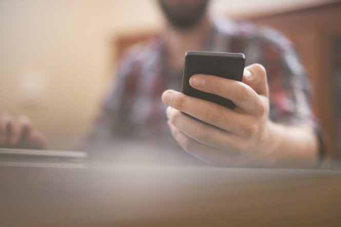 A man using two-factor authentication on his smartphone to activate a CPaaS market app