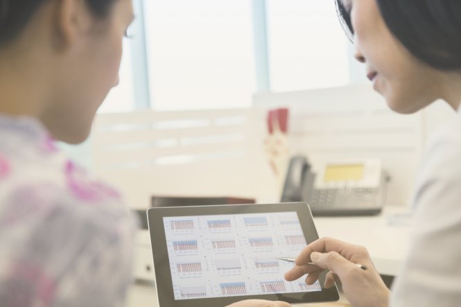 Two coworkers discuss enterprise application integration over a tablet.