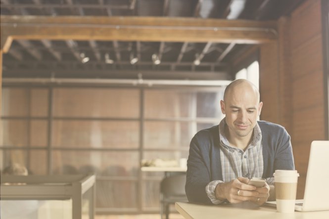 An executive uses mobile technology to take care of business from the coffee shop
