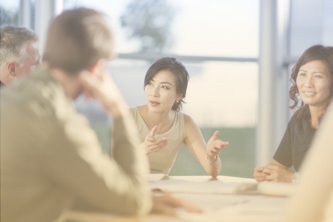 A woman giving a presentation to colleagues in a conference room