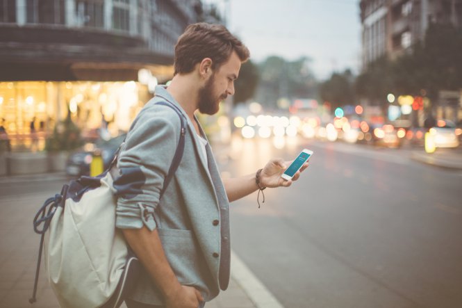 A man enjoying a favorite store's retail mobile strategy on his smartphone
