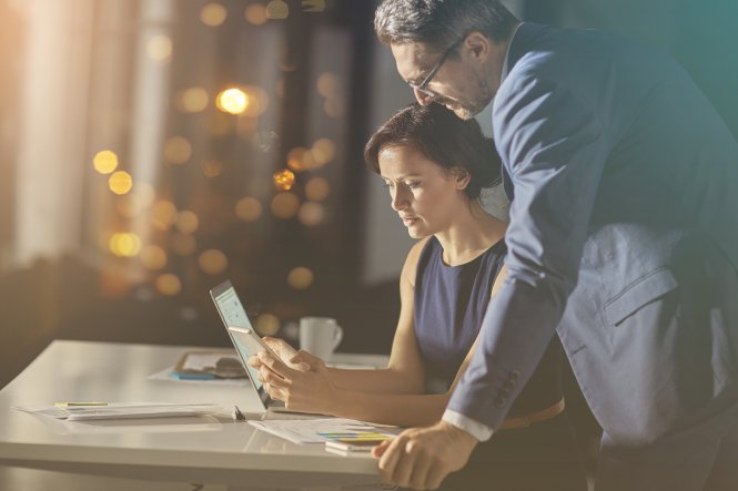 A businesswoman answers her boss when he asks