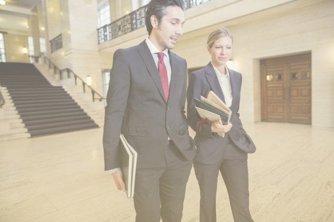 Two lawyers who use law firm billing solutions walking through a courthouse
