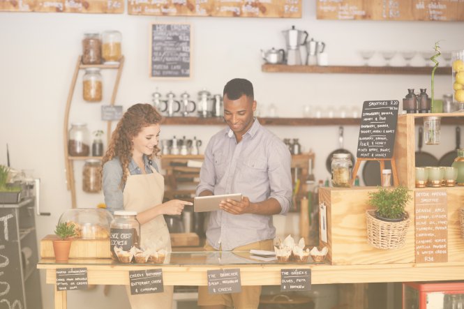A woman and man use restaurant technology on a tablet to access video conference training