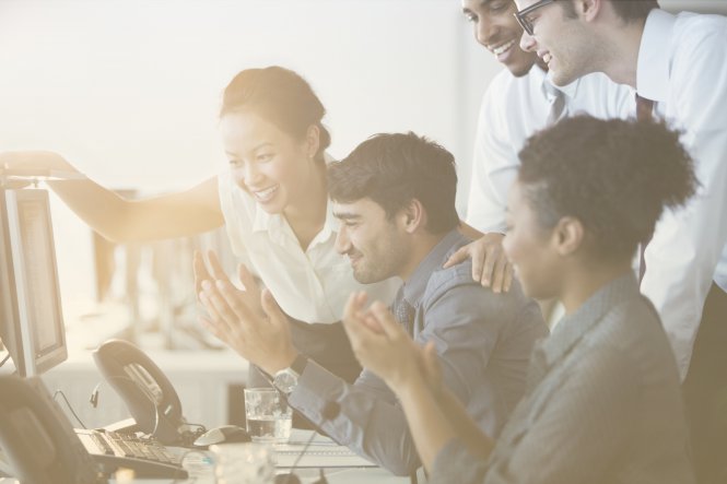 A group of smiling coworkers discussing insurance cloud solutions