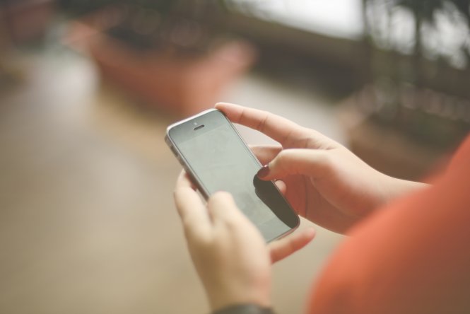 Woman enjoying benefits of SMS on her smartphone