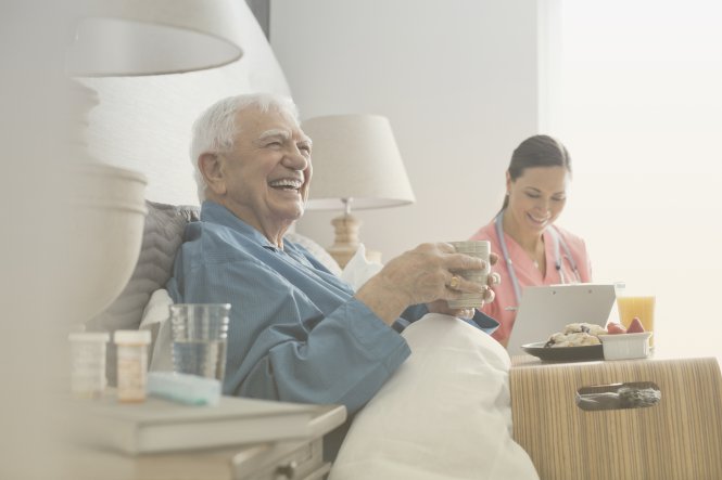 An elderly patient's caregiver uses patient care technology to communicate with a physician