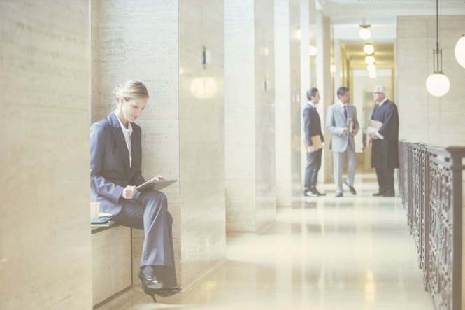 An attorney uses her laptop in a courthouse to personalize a message to a client.