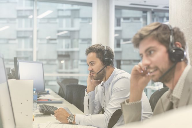 Two contact center reps use artificial intelligence in the workplace to help customers