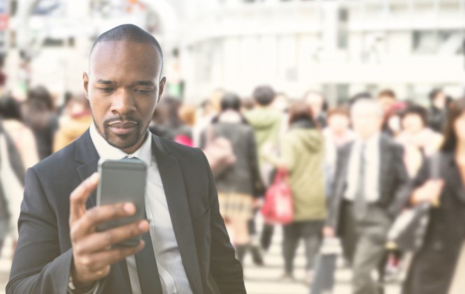 Businessperson using mobility technology amongst other businesspeople