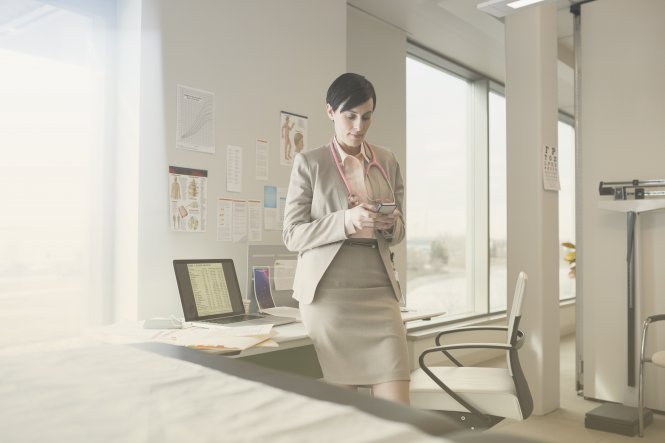 Doctor using telemedicine technology on smartphone in office to reach patient