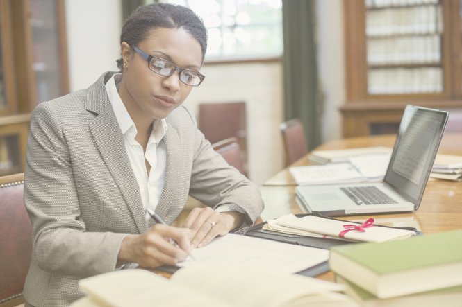 Lawyer using UC integration to communicate with clients as she studies a case strategy