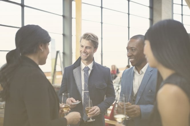 Businesspeople discussing products with drinks in hand — leverage existing customers