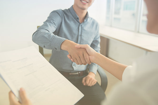 Recruiter using Bullhorn cloud and resume and shaking hands with potential hire